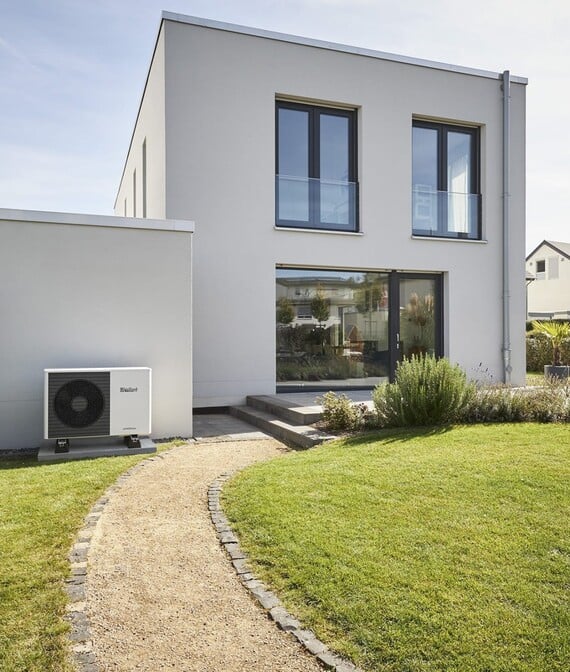 Luft-til-vann varmepumpe på utsiden av hus.